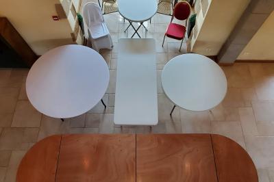 Façade d'une maison en briques et bois avec fenêtres à volets, entourée de végétation et baignée de lumière naturelle.