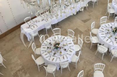 Allée éclairée par des lampes au sol, bordée d'arbres et menant à une entrée illuminée dans l'obscurité.