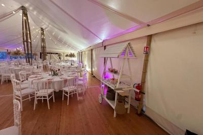 Chambre moderne avec mur vert, lit double décoré de coussins, luminaires muraux et tapis clair au sol.