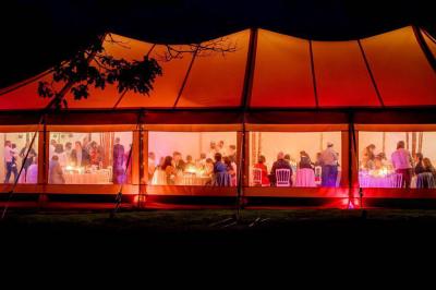 Chambre moderne avec mur vert, lit double décoré de coussins, luminaires muraux et tapis clair au sol.