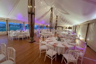 Chambre moderne avec mur vert, lit double décoré de coussins, luminaires muraux et tapis clair au sol.