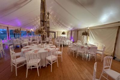 Chambre moderne avec mur vert, lit double décoré de coussins, luminaires muraux et tapis clair au sol.