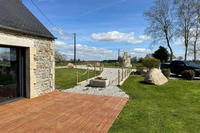Chambre moderne avec mur vert, lit double décoré de coussins, luminaires muraux et tapis clair au sol.