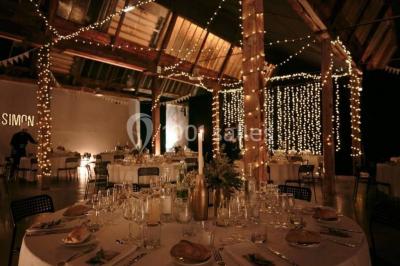 Des personnes se détendent dans une piscine extérieure avec vue sur un village et un clocher sous un ciel dégagé.