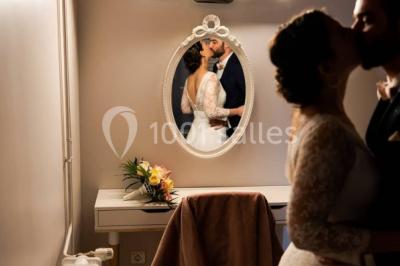 Des personnes se détendent dans une piscine extérieure avec vue sur un village et un clocher sous un ciel dégagé.