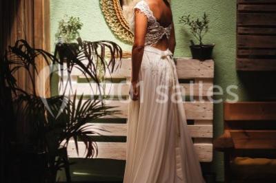 Des personnes se détendent dans une piscine extérieure avec vue sur un village et un clocher sous un ciel dégagé.