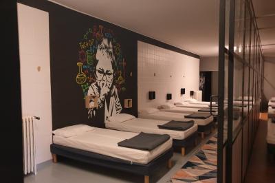 Des personnes se détendent dans une piscine extérieure avec vue sur un village et un clocher sous un ciel dégagé.