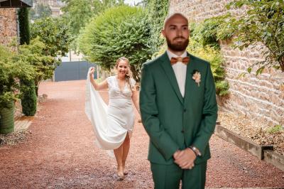 Des personnes se détendent dans une piscine extérieure avec vue sur un village et un clocher sous un ciel dégagé.