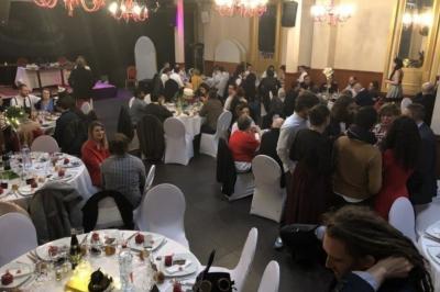 Salle sombre avec un public debout face à une scène éclairée où des musiciens jouent sous des projecteurs colorés.