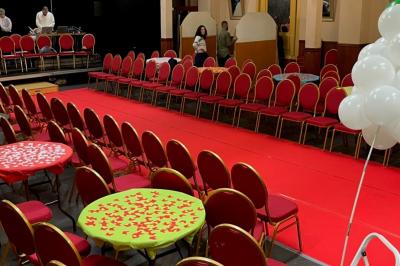 Salle sombre avec un public debout face à une scène éclairée où des musiciens jouent sous des projecteurs colorés.