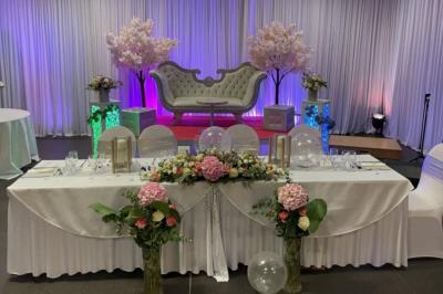 Salle sombre avec un public debout face à une scène éclairée où des musiciens jouent sous des projecteurs colorés.