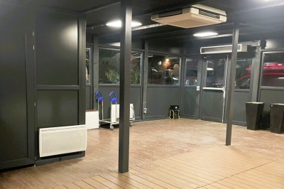 Salle sombre avec un public debout face à une scène éclairée où des musiciens jouent sous des projecteurs colorés.