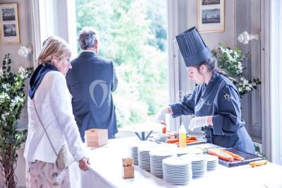Salle de réception lumineuse avec des invités assis à des tables, discutant et partageant un repas.