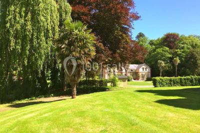 Salle de réception lumineuse avec des invités assis à des tables, discutant et partageant un repas.