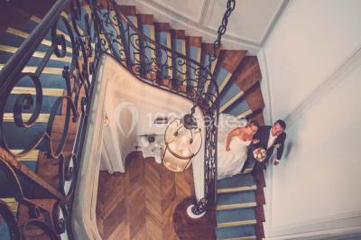 Salle de réception lumineuse avec des invités assis à des tables, discutant et partageant un repas.