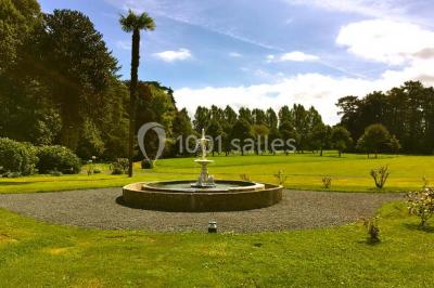 Salle de réception lumineuse avec des invités assis à des tables, discutant et partageant un repas.