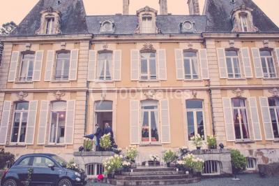 Salle de réception lumineuse avec des invités assis à des tables, discutant et partageant un repas.
