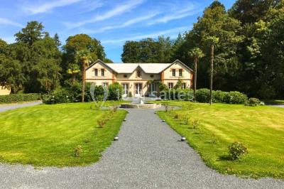Salle de réception lumineuse avec des invités assis à des tables, discutant et partageant un repas.
