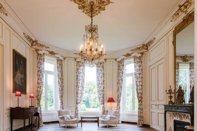 Salle de réception lumineuse avec des invités assis à des tables, discutant et partageant un repas.
