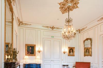 Salle de réception lumineuse avec des invités assis à des tables, discutant et partageant un repas.