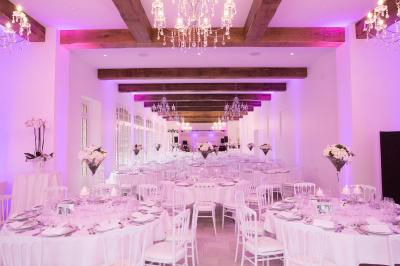 Salle de réception lumineuse avec des invités assis à des tables, discutant et partageant un repas.