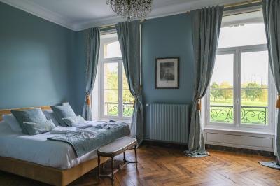 Salle de réception lumineuse avec des invités assis à des tables, discutant et partageant un repas.