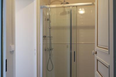 Salle de réception lumineuse avec des invités assis à des tables, discutant et partageant un repas.