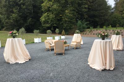 Salle de réception lumineuse avec des invités assis à des tables, discutant et partageant un repas.