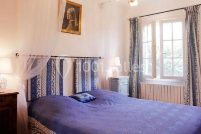 Miniature GITE MANGUIN Lavabo avec plan de travail carrelé jaune, miroir encadré en bois et murs ornés de carreaux verts et jaunes.