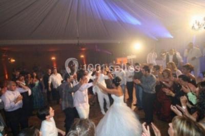 Parking extérieur avec plusieurs voitures stationnées, entouré d'arbres et offrant une vue dégagée au loin.