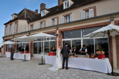 Parking extérieur avec plusieurs voitures stationnées, entouré d'arbres et offrant une vue dégagée au loin.