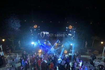 Parking extérieur avec plusieurs voitures stationnées, entouré d'arbres et offrant une vue dégagée au loin.