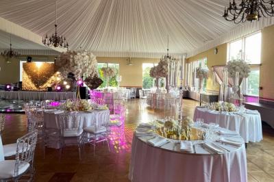 Parking extérieur avec plusieurs voitures stationnées, entouré d'arbres et offrant une vue dégagée au loin.