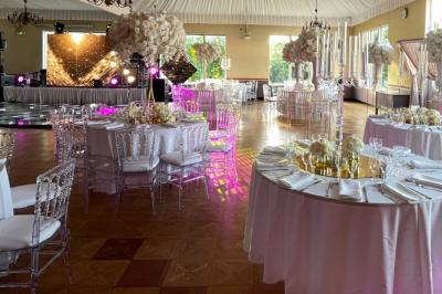 Parking extérieur avec plusieurs voitures stationnées, entouré d'arbres et offrant une vue dégagée au loin.