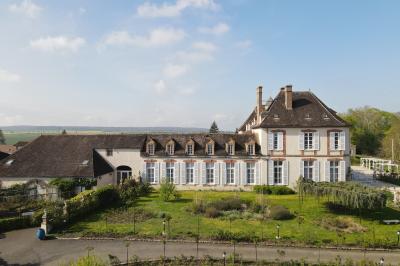 Parking extérieur avec plusieurs voitures stationnées, entouré d'arbres et offrant une vue dégagée au loin.