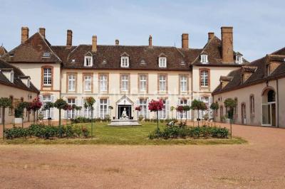Parking extérieur avec plusieurs voitures stationnées, entouré d'arbres et offrant une vue dégagée sur l'horizon.