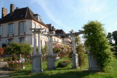 Parking extérieur avec plusieurs voitures stationnées, entouré d'arbres et offrant une vue dégagée sur l'horizon.