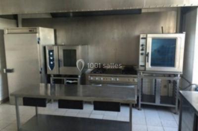 Parking extérieur avec plusieurs voitures stationnées, entouré d'arbres et offrant une vue dégagée sur l'horizon.