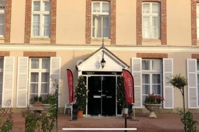 Parking extérieur avec plusieurs voitures stationnées, entouré d'arbres et offrant une vue dégagée sur l'horizon.