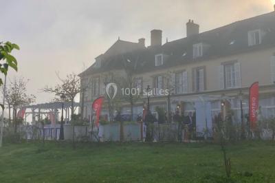 Parking extérieur avec plusieurs voitures stationnées, entouré d'arbres et offrant une vue dégagée sur l'horizon.