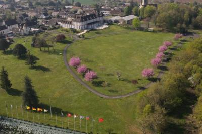 Parking extérieur avec plusieurs voitures stationnées, entouré d'arbres et offrant une vue dégagée sur l'horizon.