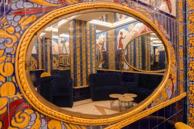 Miroirs ronds dorés reflétant des carreaux colorés ornés de motifs et illustrations dans un décor vibrant.