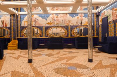 Miroirs ronds dorés reflétant des carreaux colorés ornés de motifs et illustrations dans un décor vibrant.