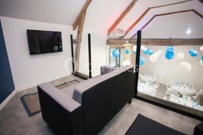 Table ronde décorée pour un repas, avec nappes blanches, couverts disposés, fleurs et éléments naturels en centre de table.