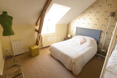 Table ronde décorée pour un repas, avec nappes blanches, couverts disposés, fleurs et éléments naturels en centre de table.
