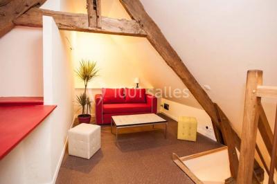 Table ronde décorée pour un repas, avec nappes blanches, couverts disposés, fleurs et éléments naturels en centre de table.