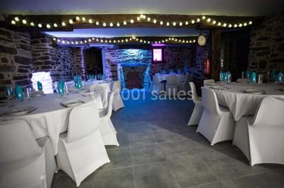 Table ronde décorée pour un repas, avec nappes blanches, couverts disposés, fleurs et éléments naturels en centre de table.