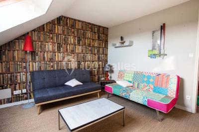 Table ronde décorée pour un repas, avec nappes blanches, couverts disposés, fleurs et éléments naturels en centre de table.