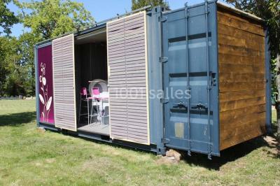 Table ronde décorée pour un repas, avec nappes blanches, couverts disposés, fleurs et éléments naturels en centre de table.