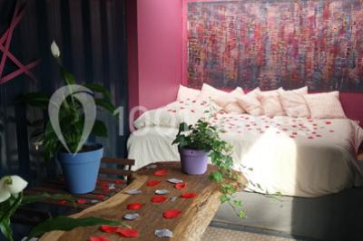 Table ronde décorée pour un repas, avec nappes blanches, couverts disposés, fleurs et éléments naturels en centre de table.